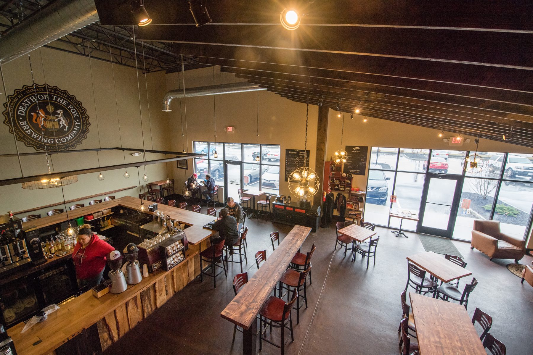 The full Death of the Fox tasting room in Clarksboro, with long wooden tables and the bar