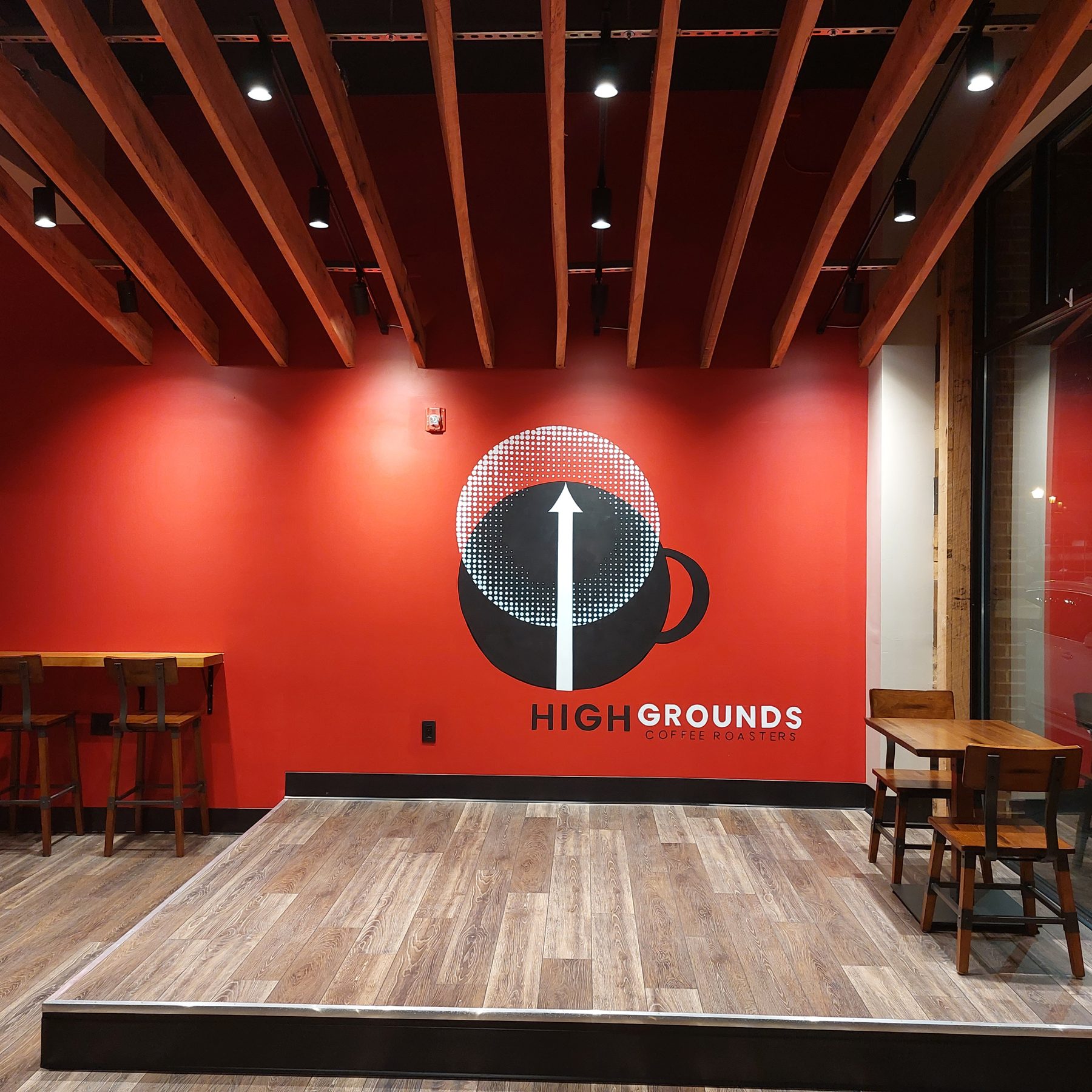Stage in front of the red High Grounds Coffee Roasters logo wall in Glassboro
