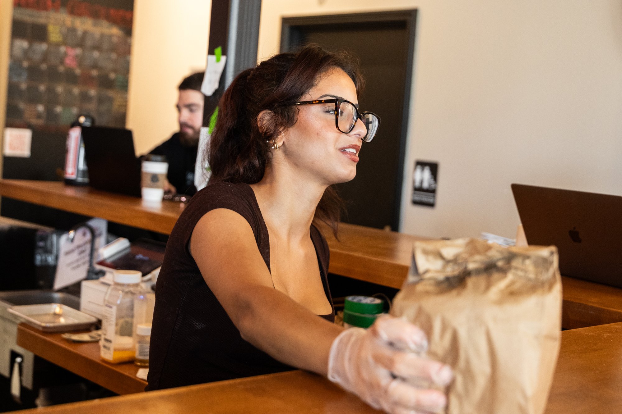 Staff member handing over an order at High Grounds Coffee Roasters, Glassboro